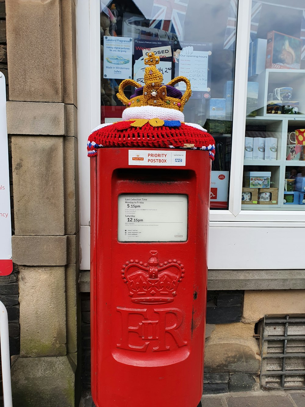 a red mailbox with a crown on top of it