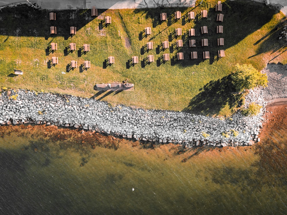 an aerial view of a grassy area next to a body of water