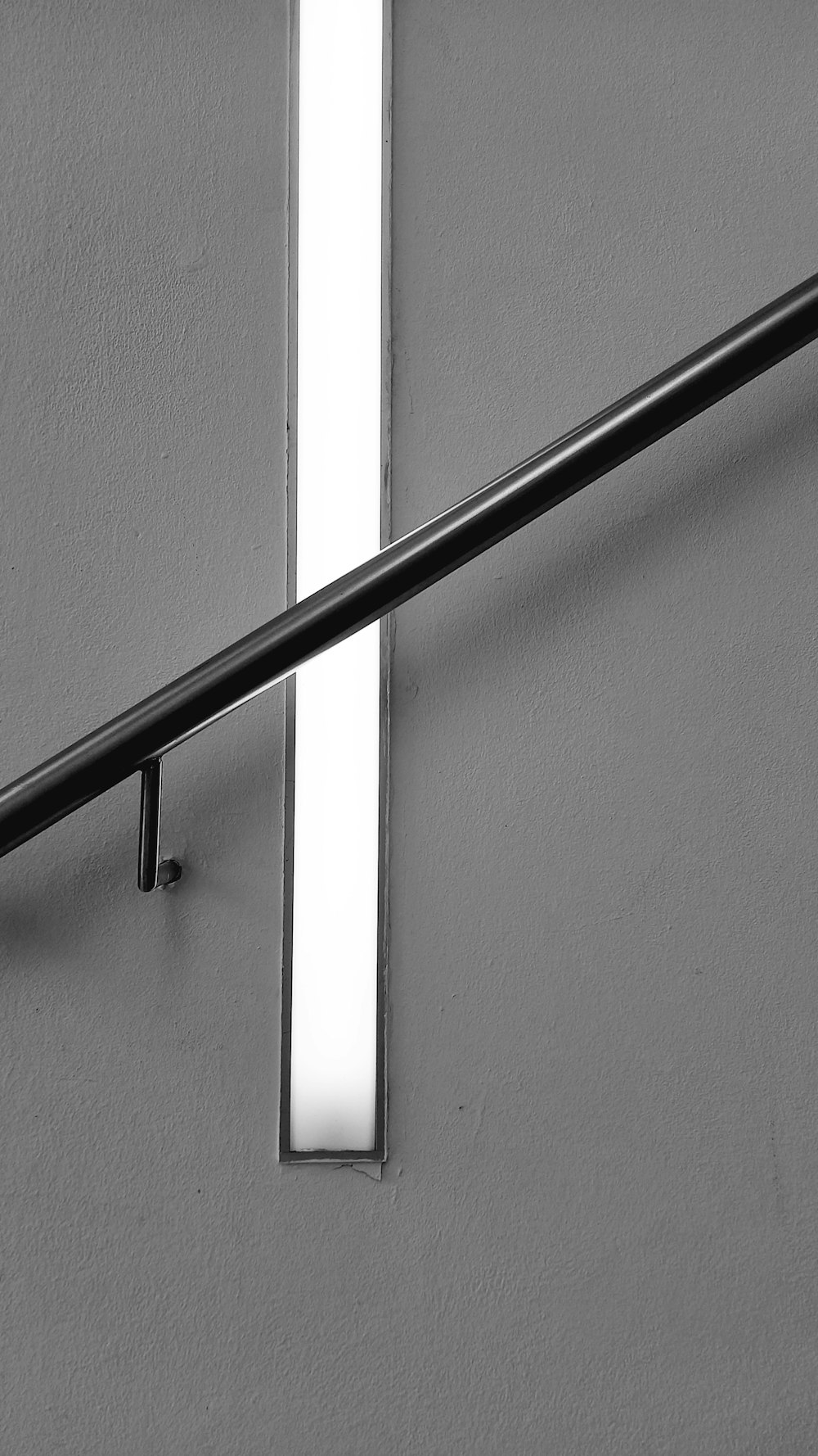 a black and white photo of a cross on a wall