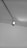 A ceiling-mounted spotlight is illuminating a portion of a smooth, flat ceiling. The spotlight appears to be attached to an adjustable track system.