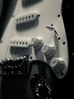 a close up of an electric guitar with white knobs