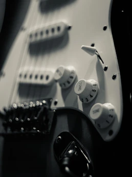a close up of an electric guitar with white knobs