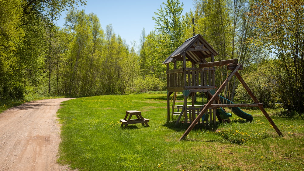 a wooden play set in the middle of a field