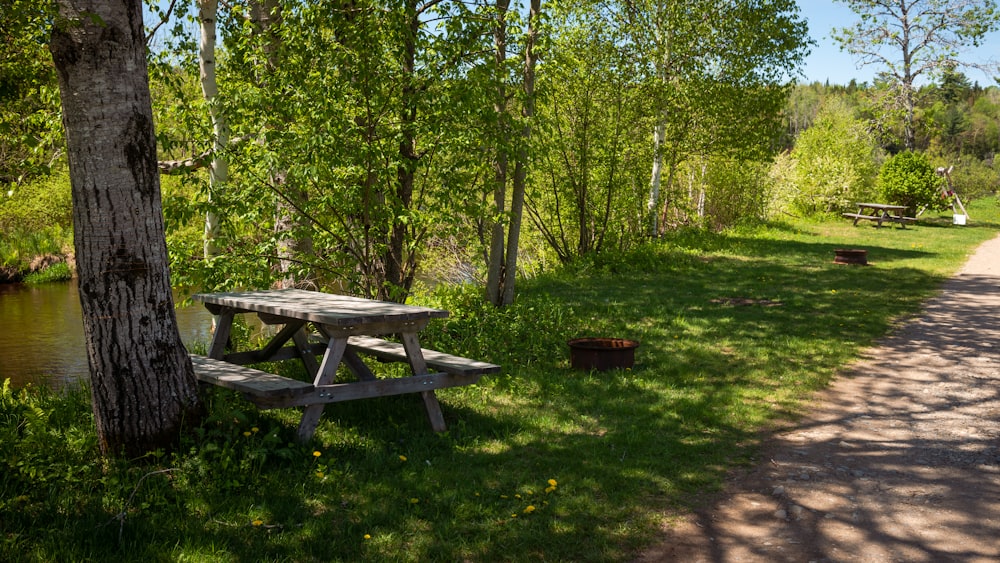 a picnic table next to a river in the woods