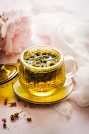 a cup of green tea next to some flowers