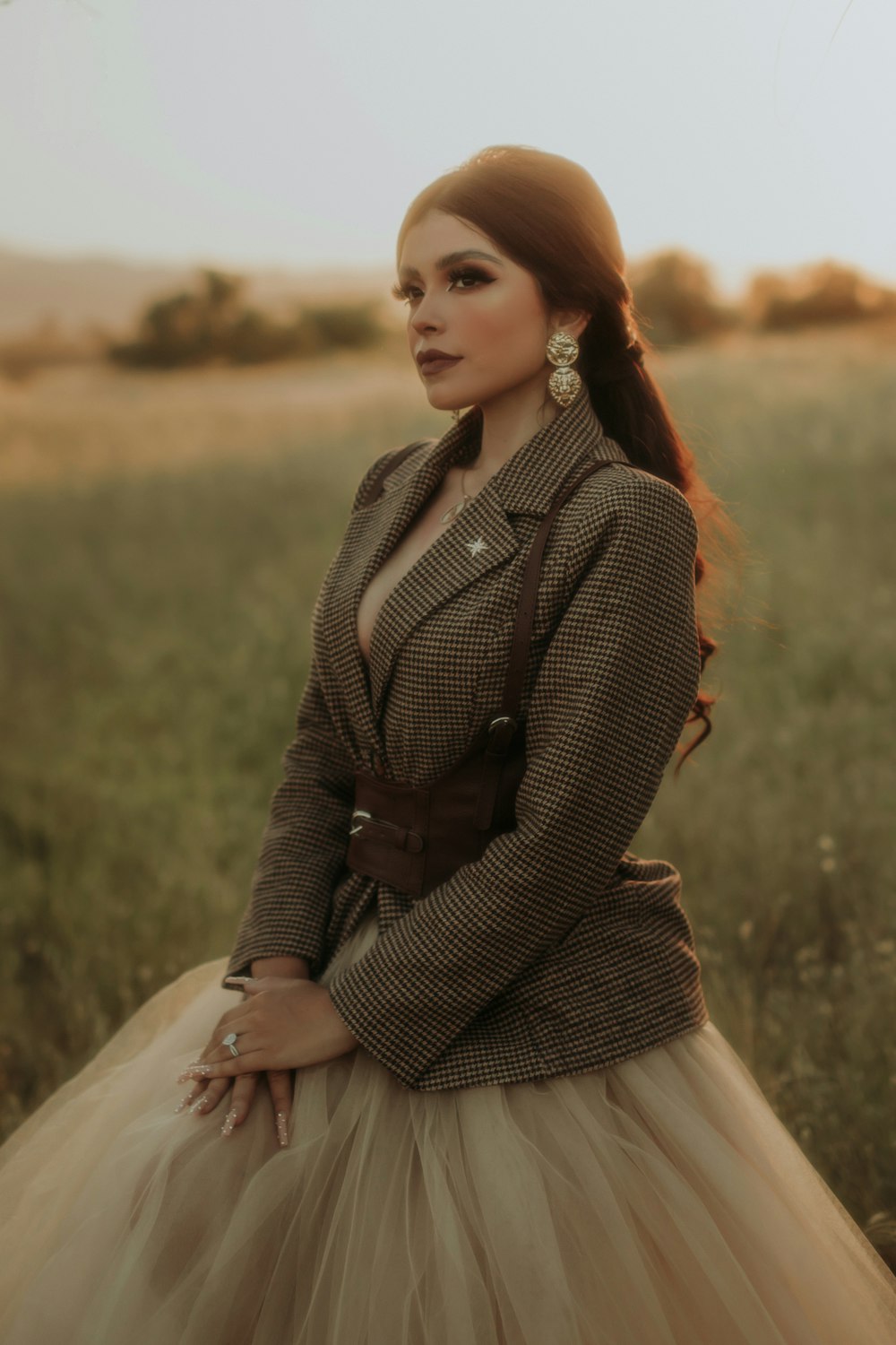 a woman standing in a field wearing a skirt