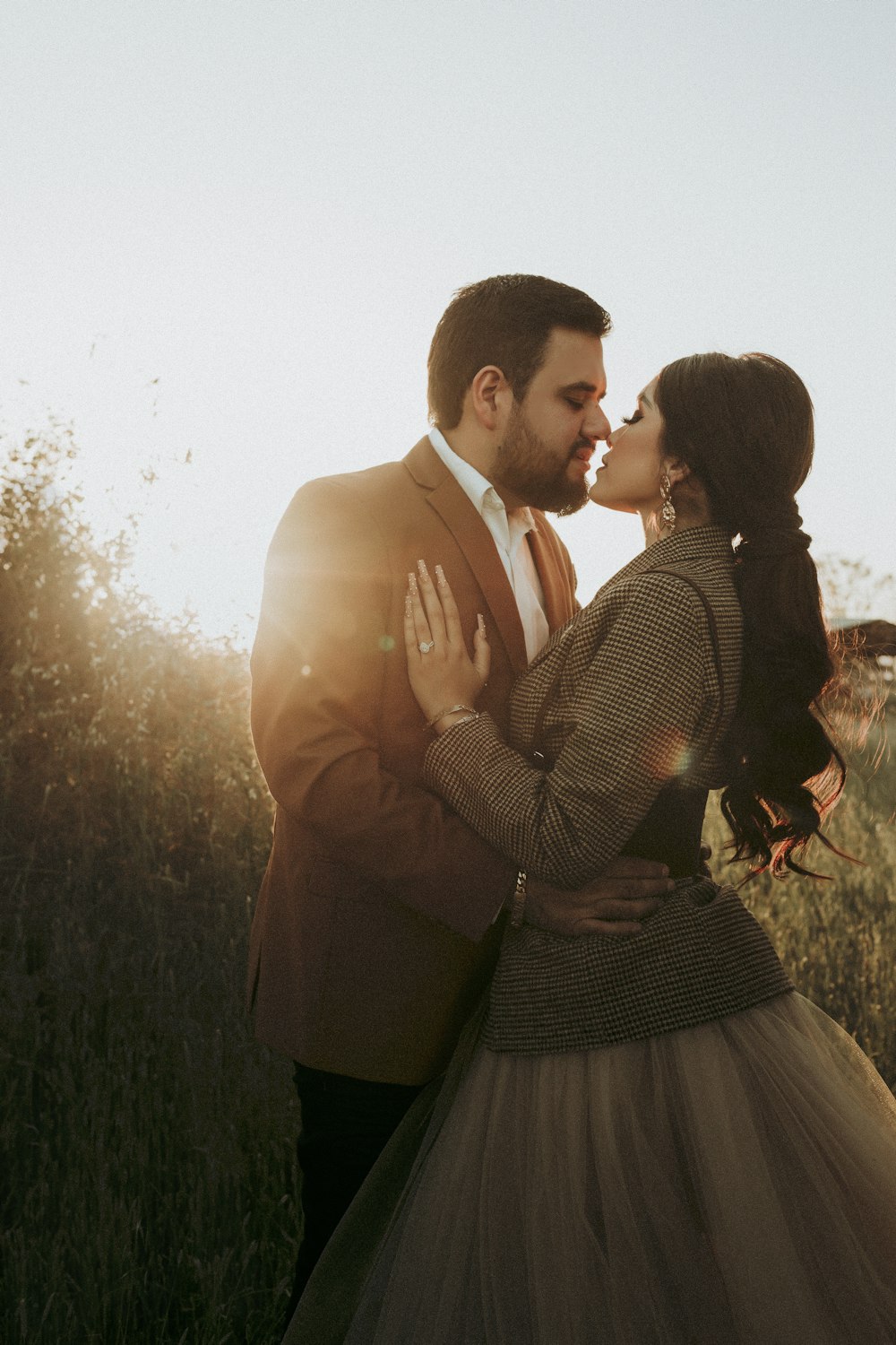 a man and a woman kissing in a field