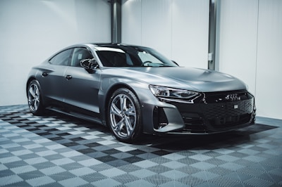 a silver car parked in a garage with a checkered floor
