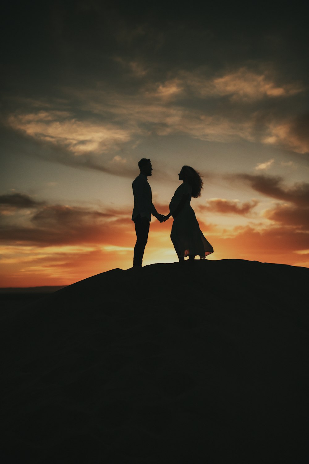 a couple of people standing on top of a hill