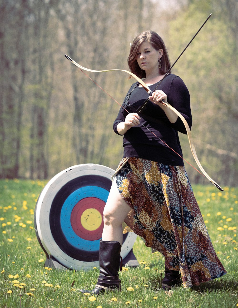 Una mujer sostiene un arco y una flecha
