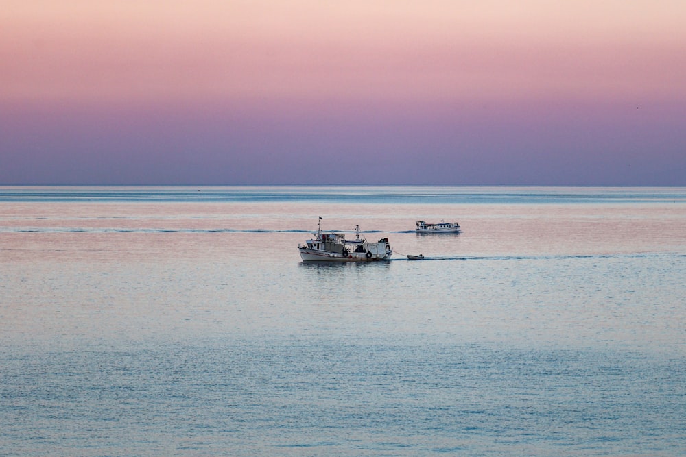 a couple of boats floating on top of a large body of water