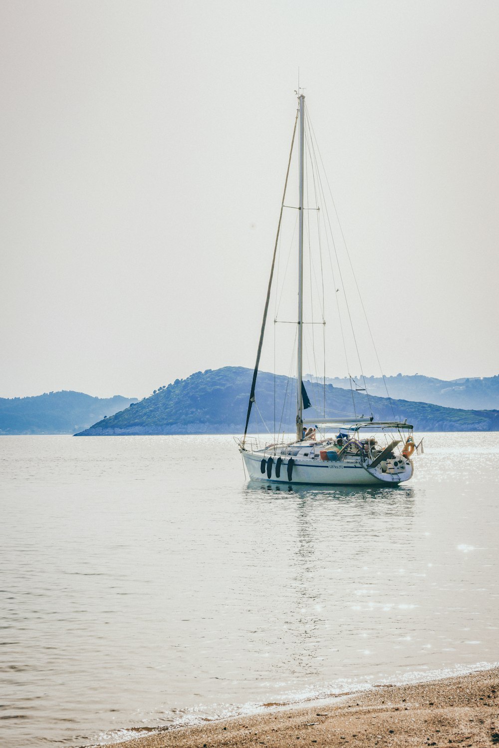 Una barca a vela sull'acqua con le montagne sullo sfondo