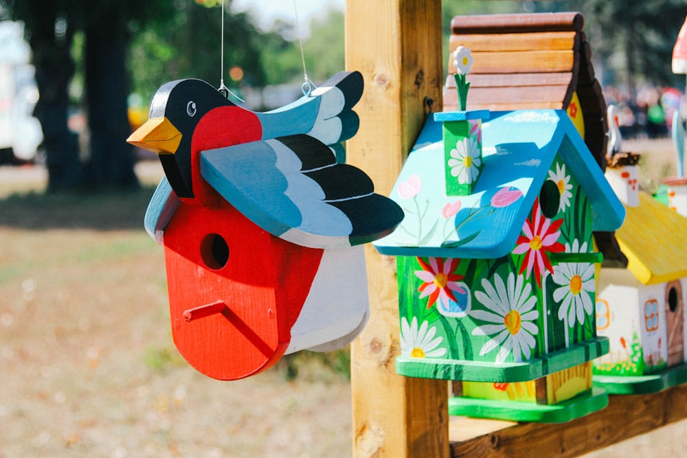 a birdhouse and bird feeder hanging from a wooden pole