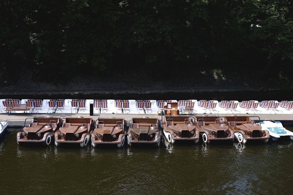 a row of lawn chairs sitting next to a body of water