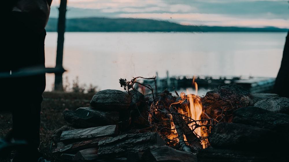 a campfire with a lake in the background