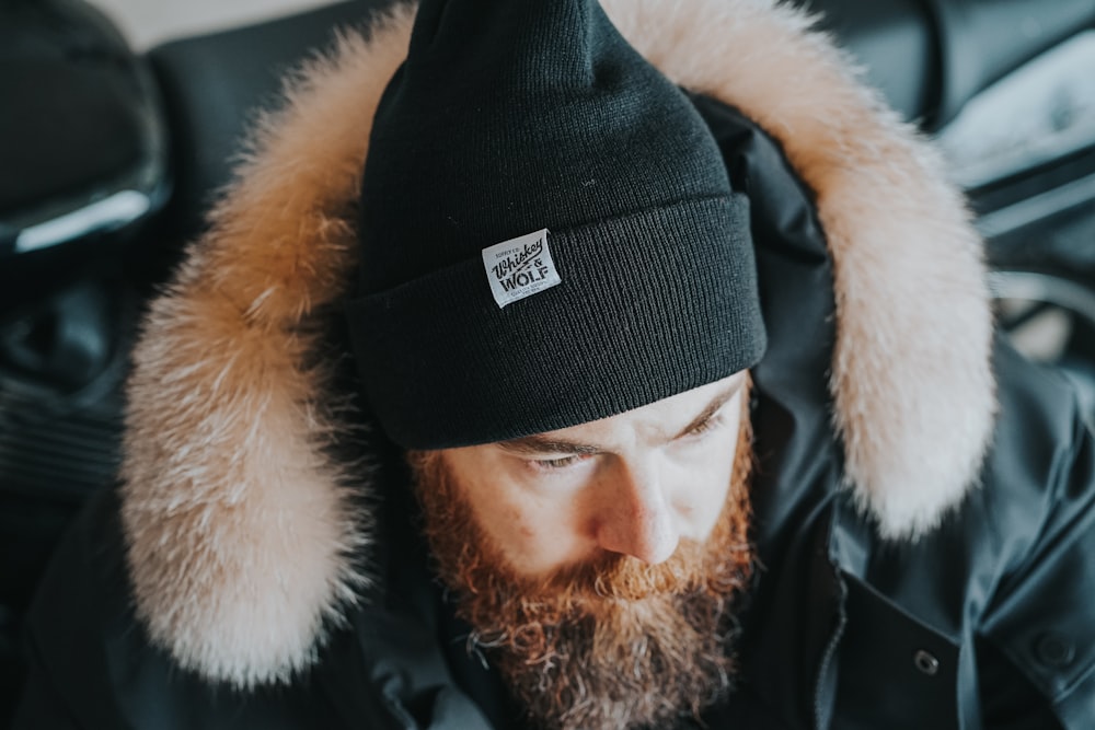 a man with a beard wearing a black hat