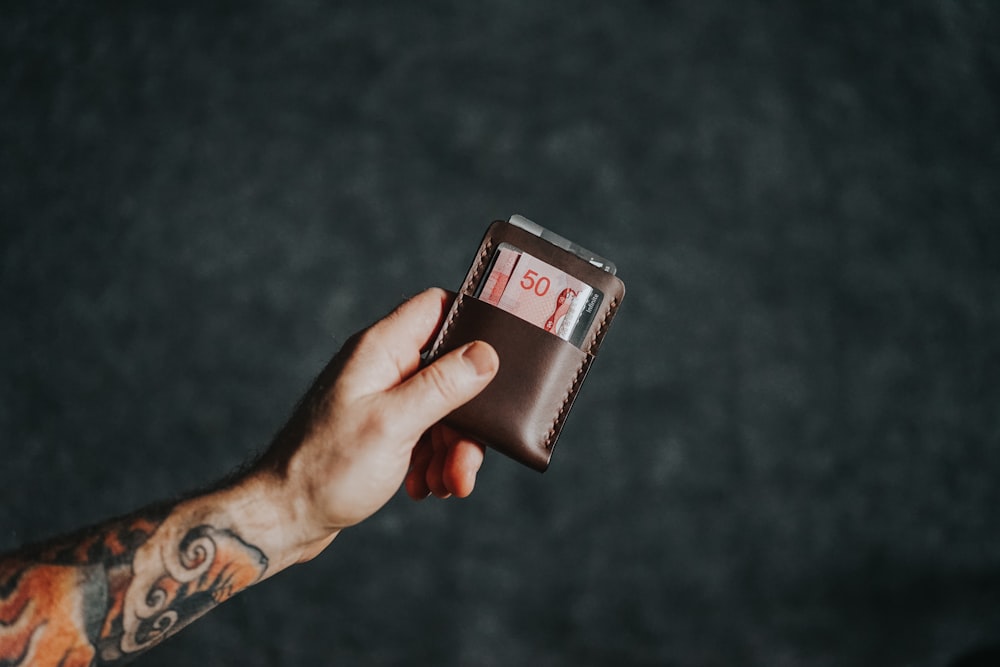 a person holding a wallet with a number on it