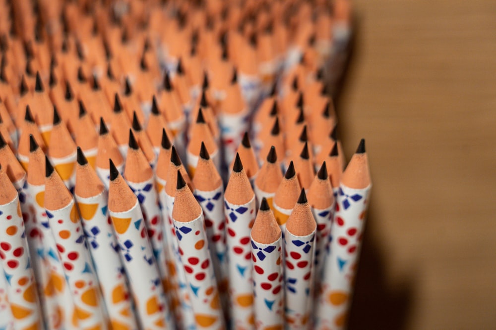 a close up of a bunch of orange colored pencils