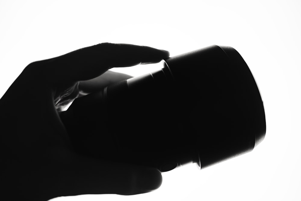 ein Schwarz-Weiß-Foto einer Person, die eine Tasse hält
