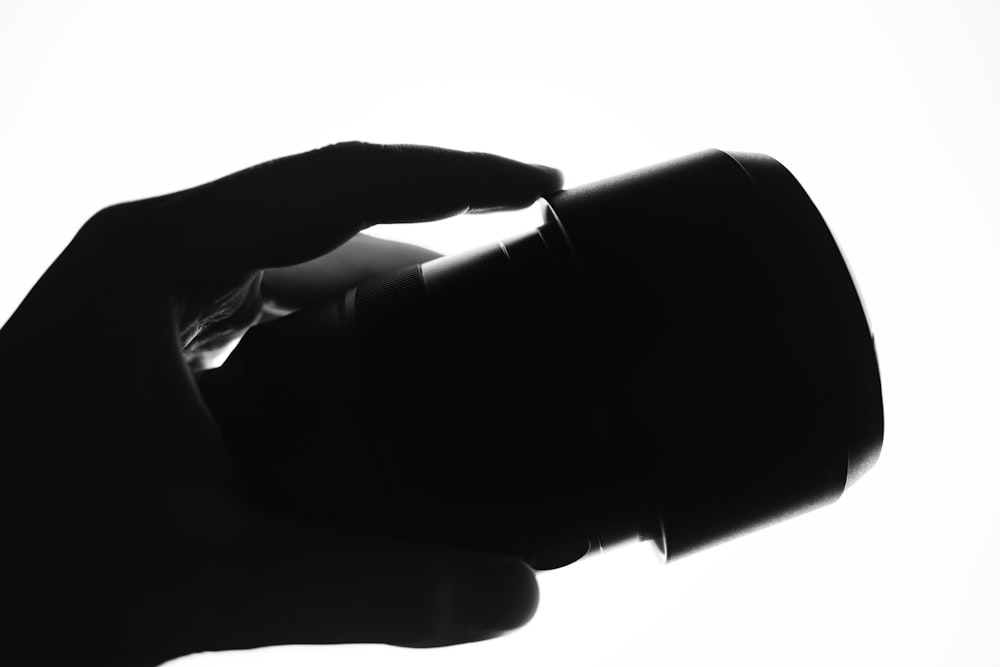 a black and white photo of a person holding a cup