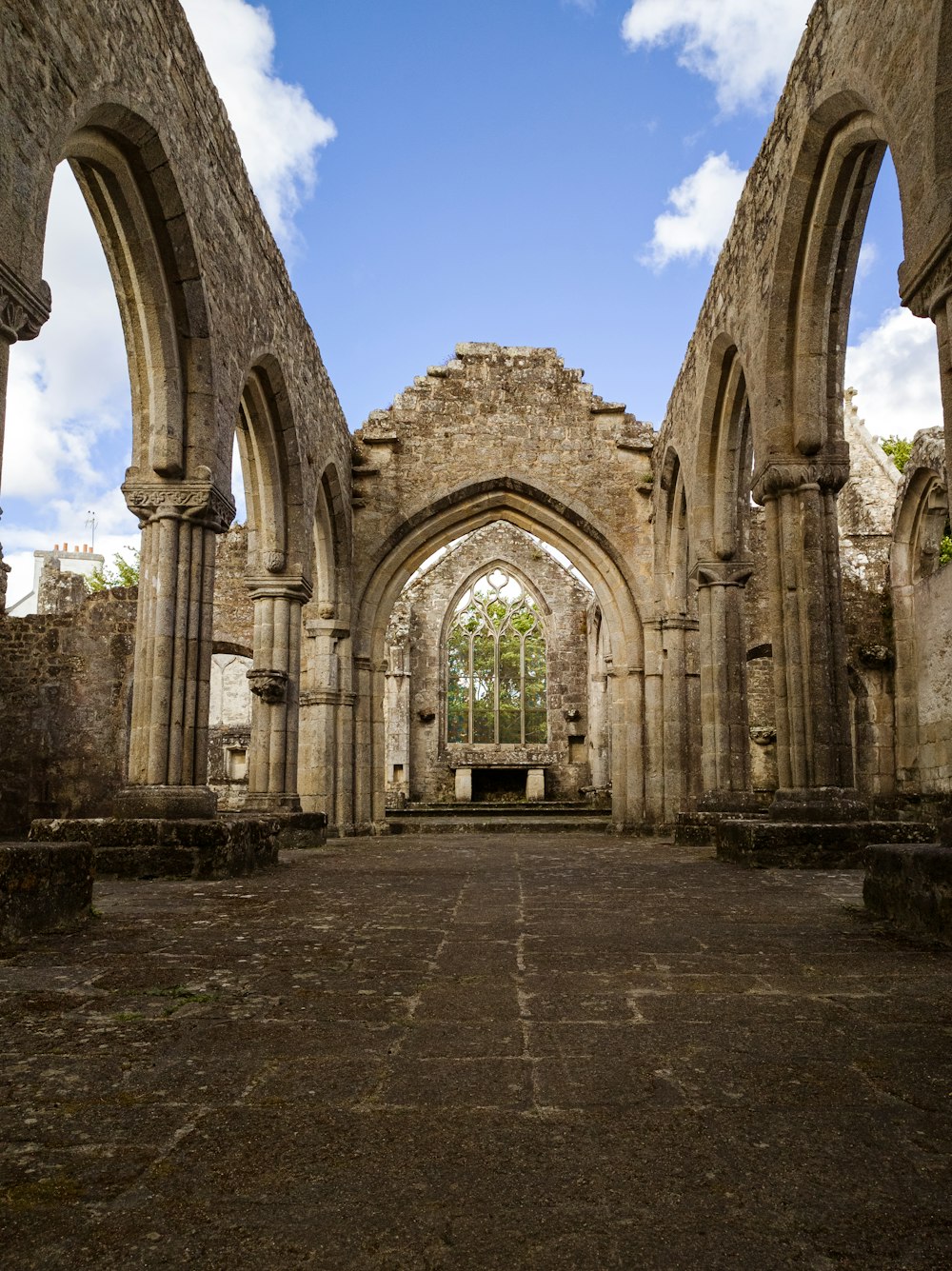 a large stone building with arches and a sky background