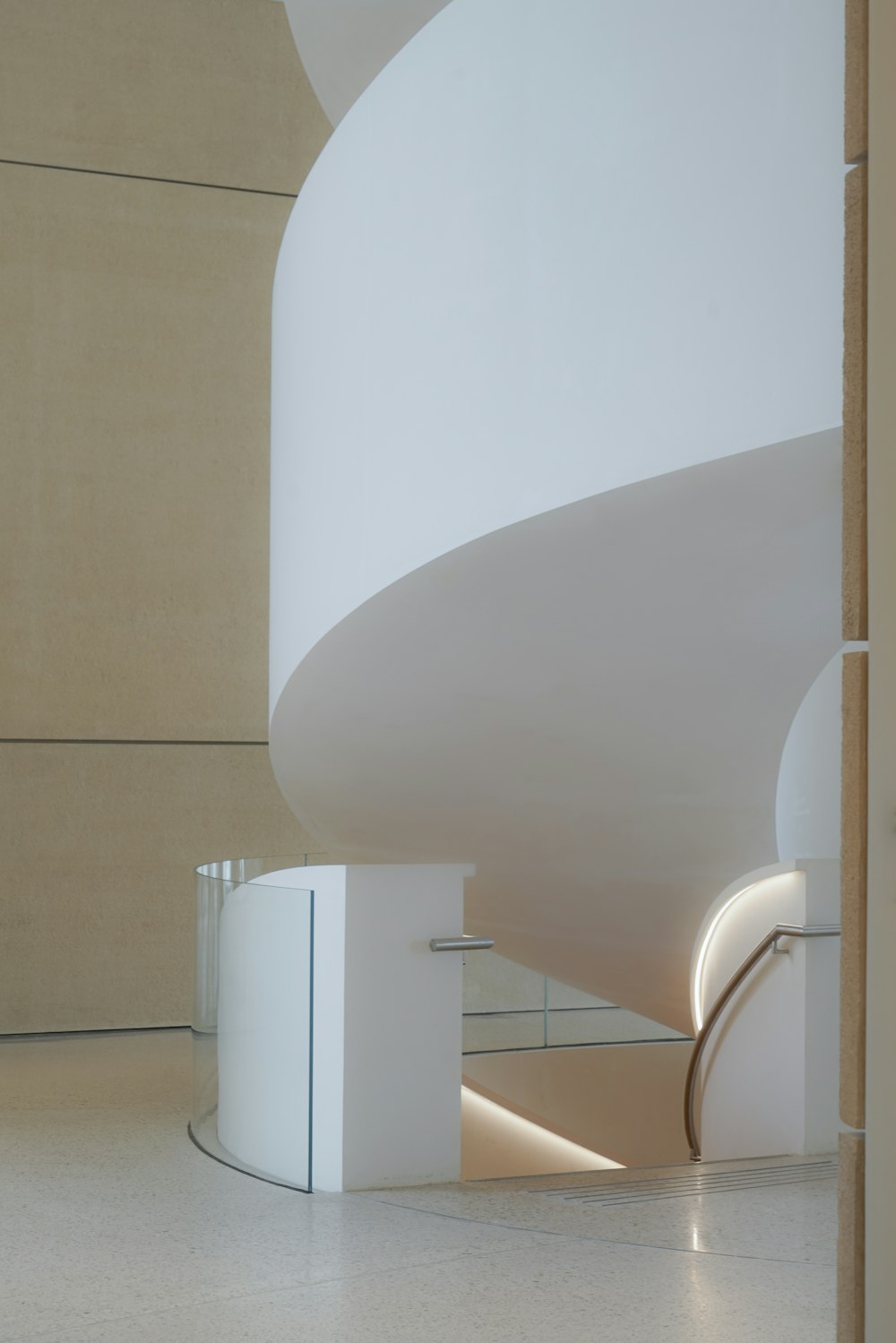 a curved staircase in a building with white walls