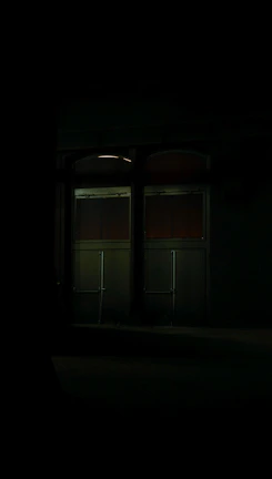 Close-up of a haunted mansion’s creaky door slightly ajar, glowing with ominous light.
