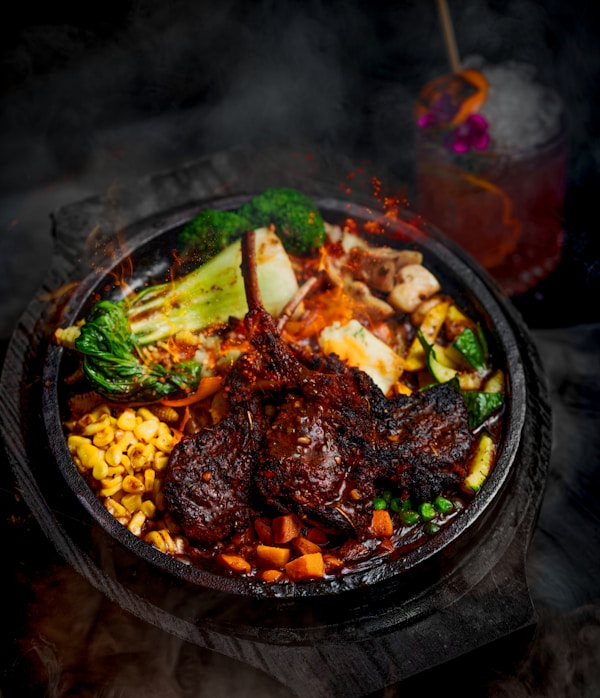 A plate of food with meat, vegetables and corn