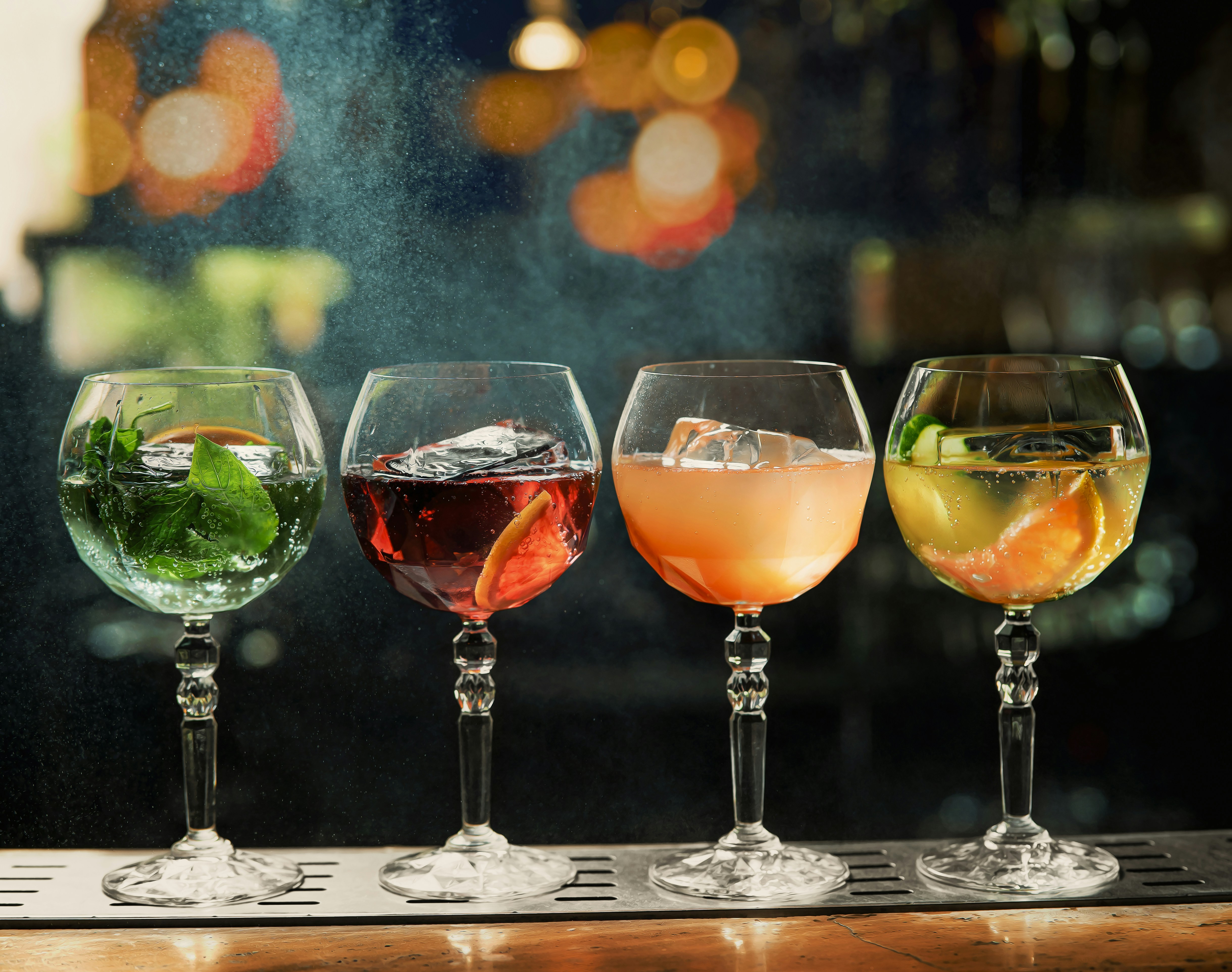 a row of wine glasses filled with different types of drinks