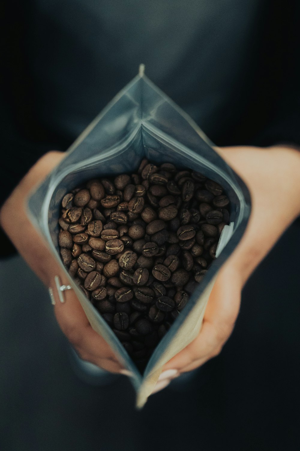 a person holding a bag full of coffee beans