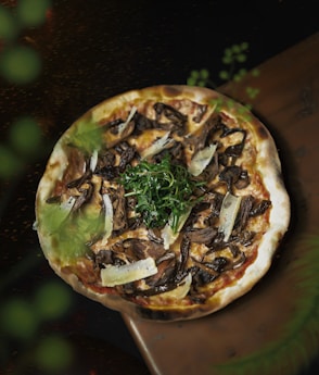 a pizza with mushrooms, cheese, and greens on it