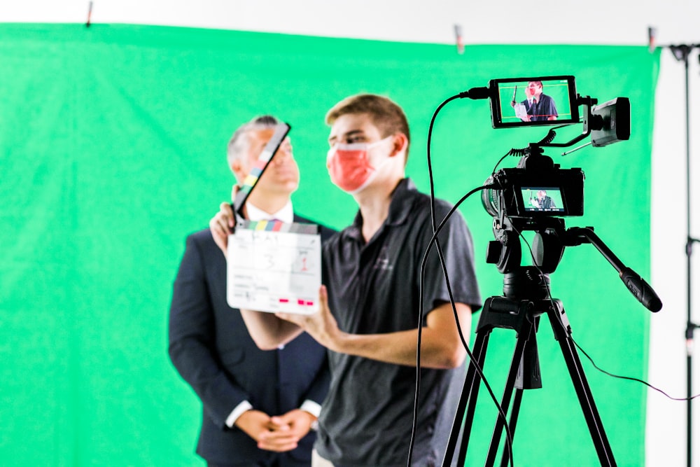 a man holding a camera and a video camera