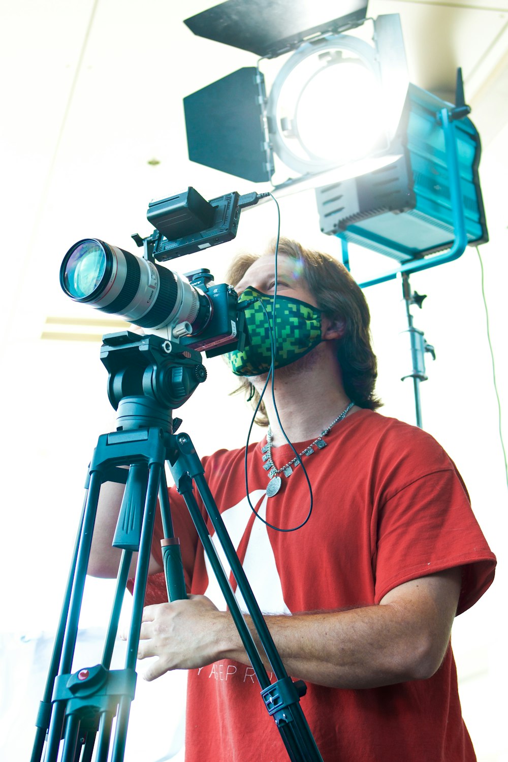 a man in a red shirt and a camera