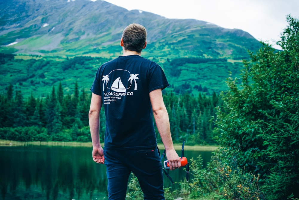 a man standing on a rock near a body of water