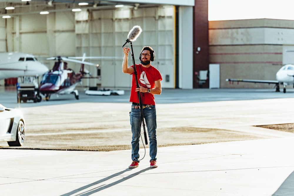 a man holding a baseball bat on top of a tarmac