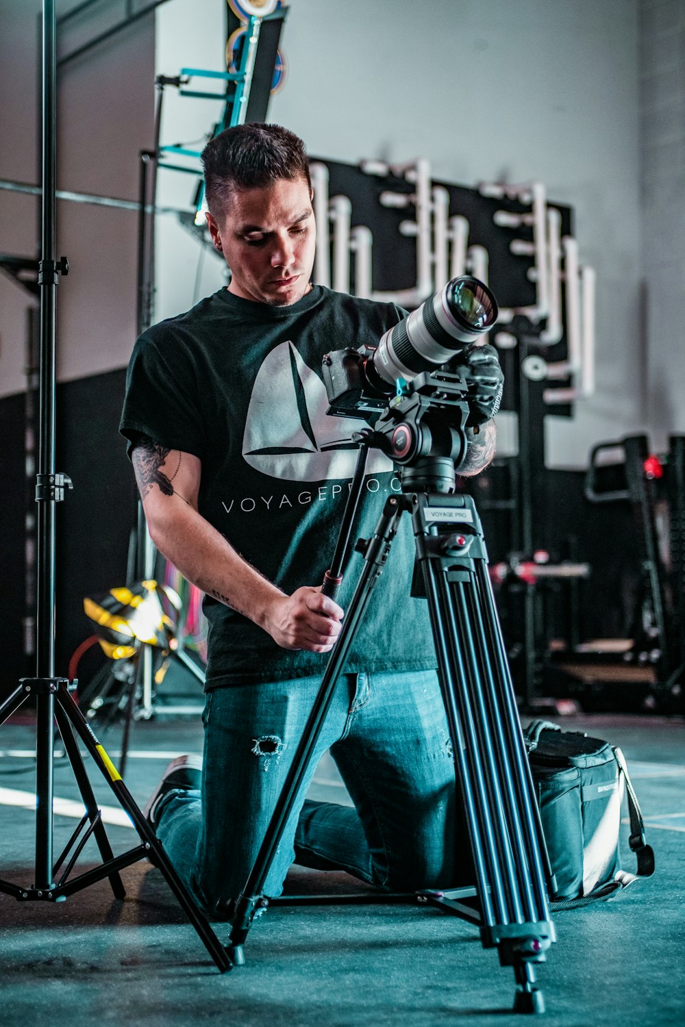 a man holding a camera in front of a tripod
