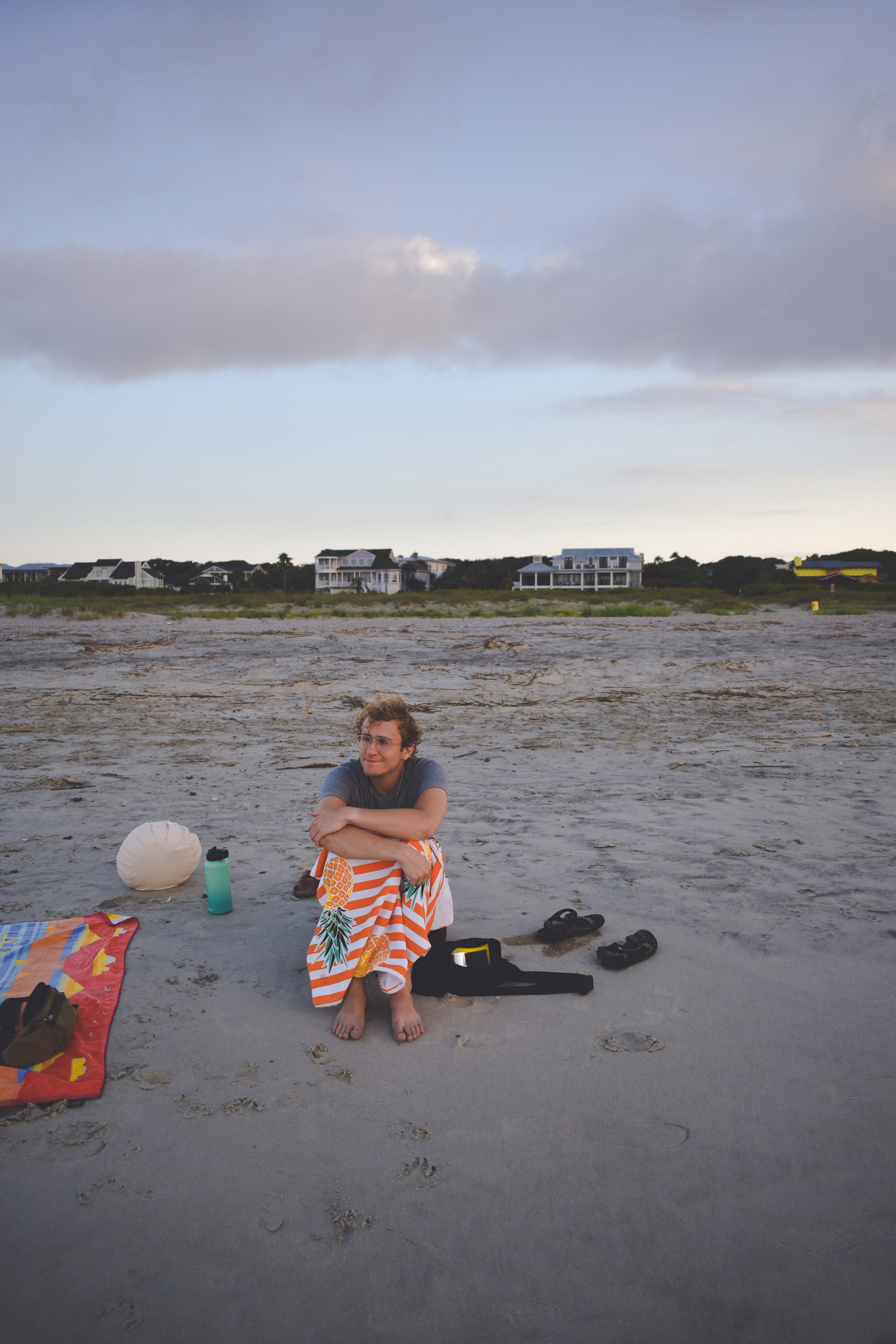 Eine Frau sitzt am Strand neben einem Ball