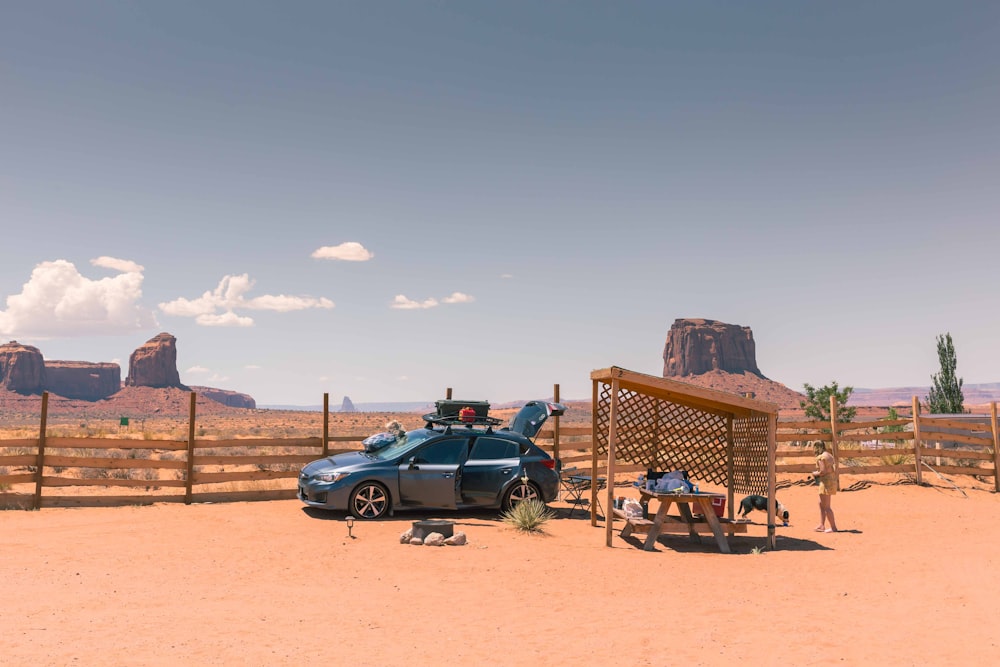 a car parked in front of a wooden fence