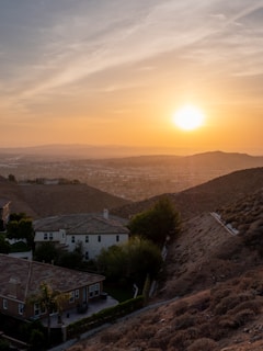 Sunset view over terracotta-colored homes with lush greenery in San Lorenzo.