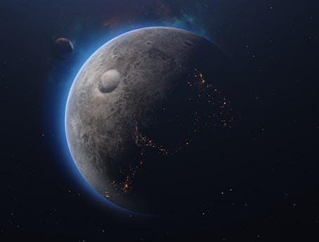A celestial scene featuring a planet with a textured, cratered surface. The planet's edges are illuminated with a blue glow, highlighting a partial view of illuminated patterns resembling city lights. Another smaller celestial body is visible at a distance, adding depth to the space scene.