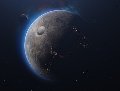 A celestial scene featuring a planet with a textured, cratered surface. The planet's edges are illuminated with a blue glow, highlighting a partial view of illuminated patterns resembling city lights. Another smaller celestial body is visible at a distance, adding depth to the space scene.