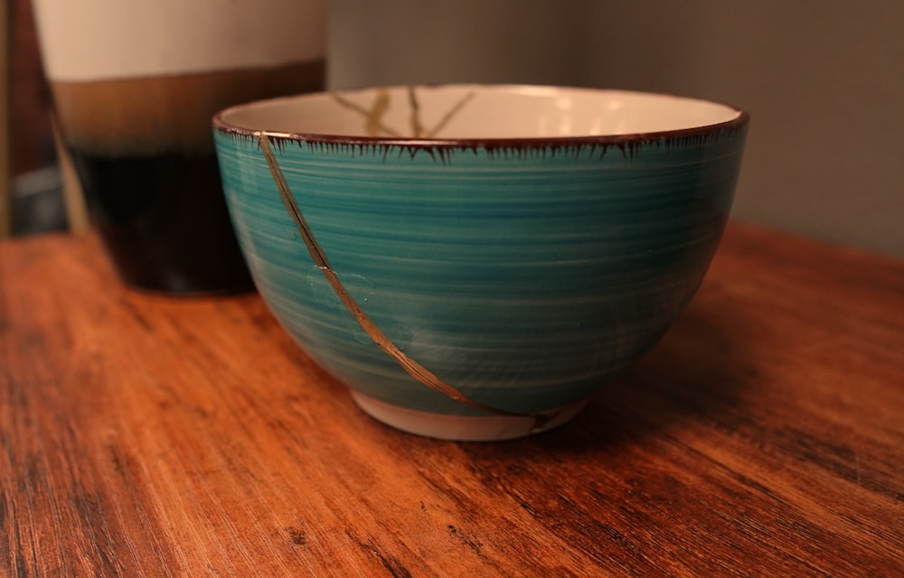 a blue and white bowl sitting on top of a wooden table