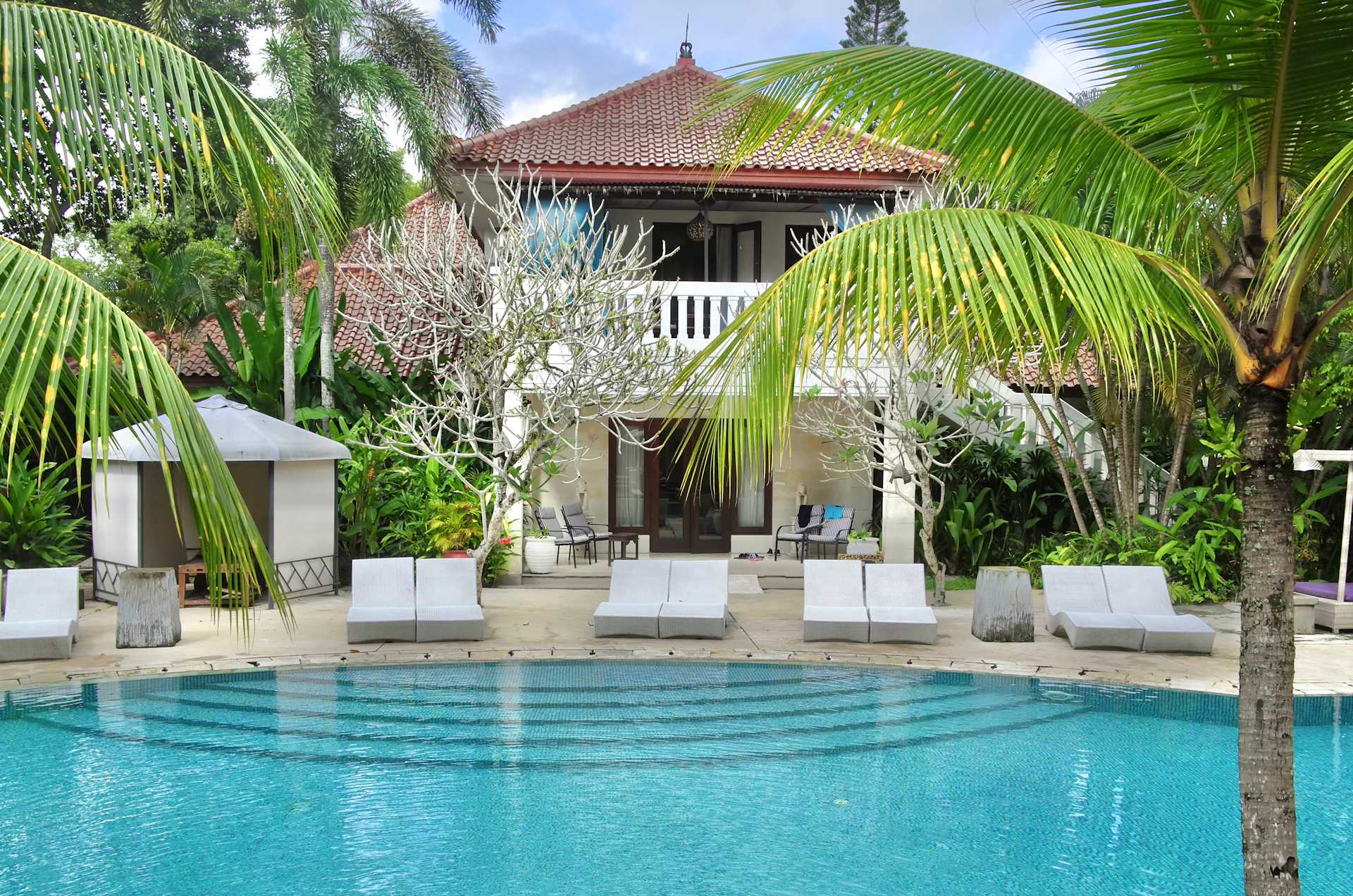 Tropical wellness resort pool surrounded by palm trees, Southeast Asia