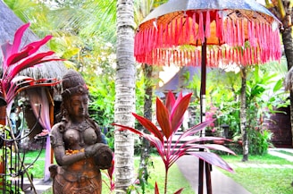 a statue of a woman holding a baby in a garden