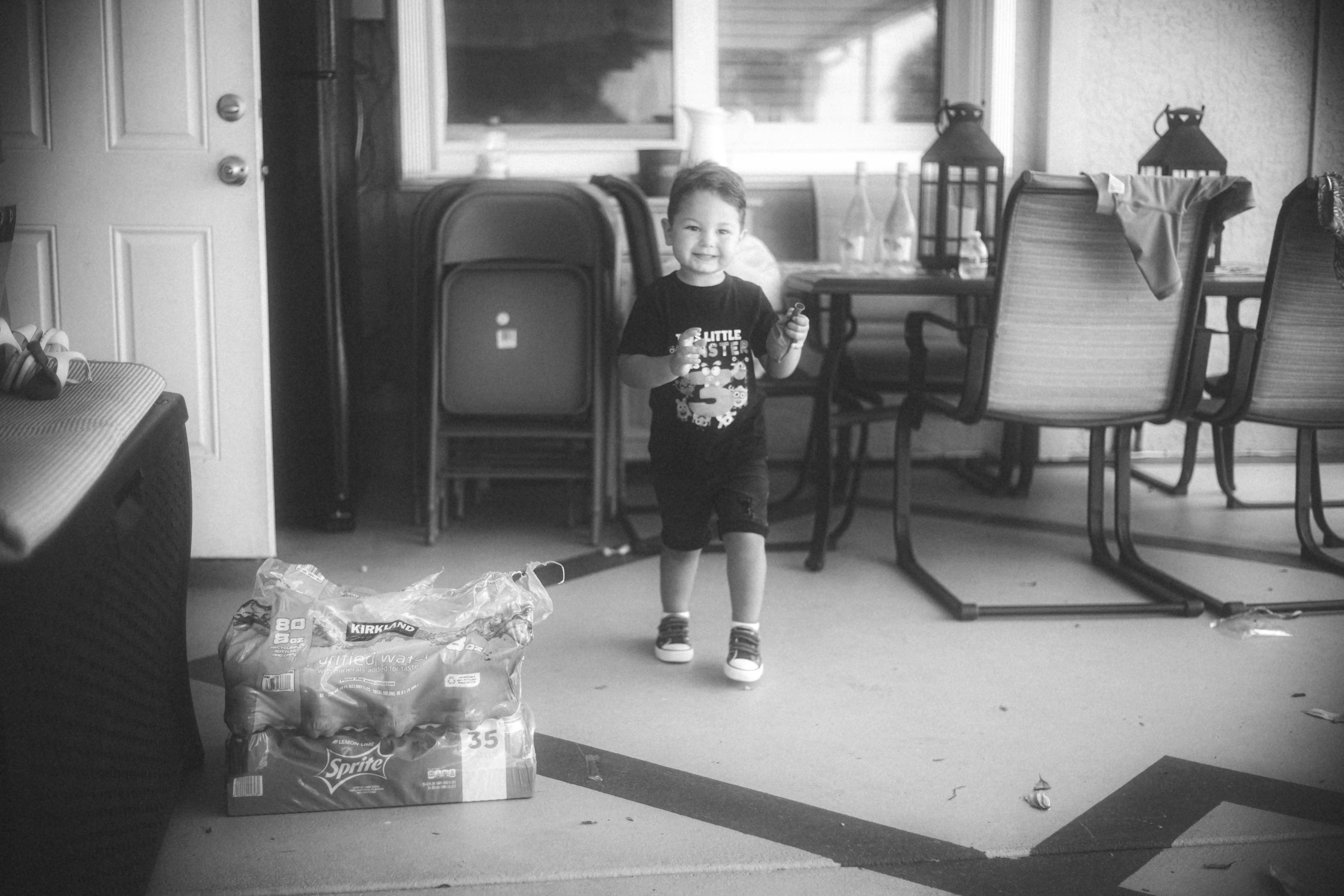 a little boy standing in a living room next to a table