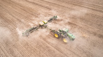 a tractor plowing a field with a sprayer