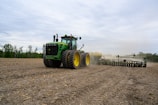 a tractor pulling a plow behind it on a farm