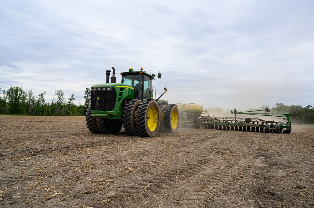 a tractor pulling a plow behind it on a farm