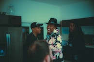 A group laughing heartily during an intimate community gathering inside a warmly lit room.