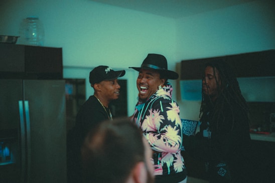 A lively group of friends laughing together in a cozy, colorful room filled with playful gadgets.